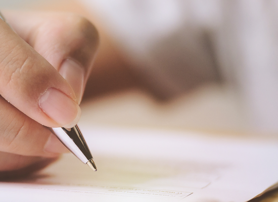 Hand holding pen over form Hand holding pen over form